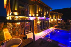 a house with a swimming pool at night at champion villas in Ortaca
