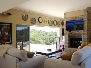 a living room with white couches and a fireplace at Castle On The Heads in Knysna