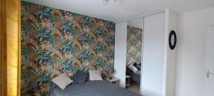 a bedroom with a bed with a floral wallpaper at iledo in La Cotinière