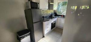 a small kitchen with a refrigerator and a microwave at HAPPY JUNGLE at 6 in St Lucia