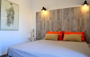 1 dormitorio con 1 cama blanca grande con almohadas de color naranja en B&B La Casa Bianca di Porto Conte en Porto Conte