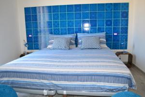 a bed with a blue tiled headboard in a bedroom at B&B La Casa Bianca di Porto Conte in Porto Conte