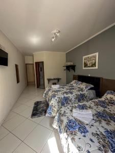 a bedroom with two beds and a table in it at Prime Garden Pousada in Socorro