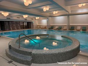a large pool with a hot tub in a hotel room at Alpine Line Studio with pool & spa in Sinaia