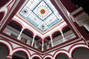 a glass ceiling with a skylight in a building at Sercotel Las Casas de los Mercaderes in Seville