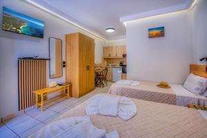 a hotel room with two beds and a kitchen at Christinas apartments in Ágios Matthaíos +51 photos