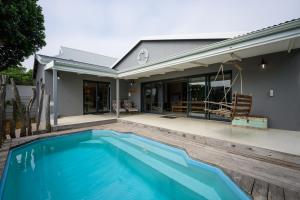 a swimming pool in front of a house at Inverell Station by The Oyster Collection in Kenton on Sea