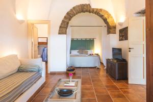 a living room with a couch and a bed at Dammuso del Nonno in Pantelleria