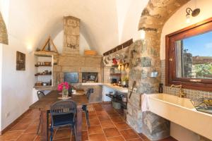 a kitchen with a table and a stone wall at Dammuso del Nonno in Pantelleria