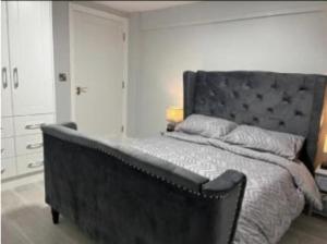 a bedroom with a large bed with a black headboard at The Captains Wheel in Skerries