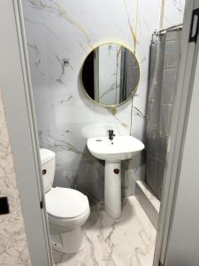 a bathroom with a toilet and a sink and a mirror at Adel in Almaty