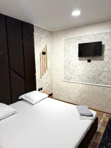 a bedroom with two beds and a flat screen tv at Adel in Almaty