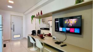 a kitchen with a counter with a tv on the wall at Flat Ilha do Leite in Recife