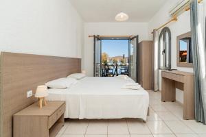 a bedroom with a large bed and a balcony at Lena Apartments in Elounda