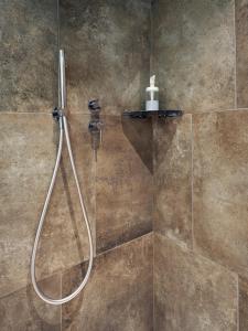 a shower with a hose in a bathroom at Appartamento Food Truck 11 in Muralto
