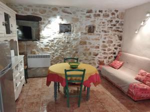 a kitchen with a table and a couch in a room at Gîte Côté Sud in Vagnas +4 photos