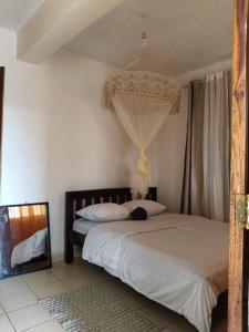a bedroom with a bed with a chandelier at Amirah Homes in Machakos