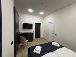 a bedroom with a bed and a desk and a television at Old Well Hotel in Tsaghkadzor