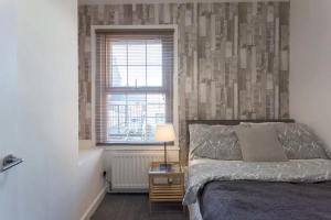 1 dormitorio con cama y ventana en Hastings House, en Luton