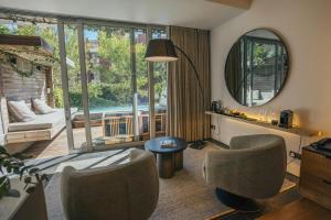 a living room with chairs and a large mirror at POD Camps Bay by The Oyster Collection in Cape Town +57 photos