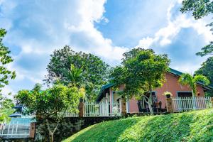a house on a hill with a fence and trees at Rose Villa by Kananke Hills in Kananke