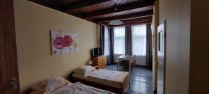 a bedroom with two beds and a desk and a window at Willa Wiselka in Wisełka