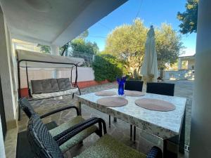 a table with two chairs and a umbrella on a patio at Bungalow Punta in Umag