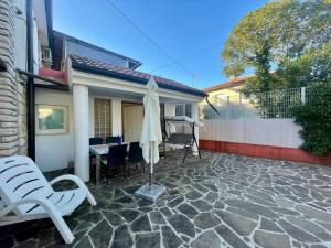 a patio with a table and chairs and an umbrella at Bungalow Punta in Umag