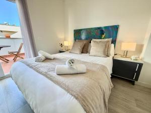a bedroom with a large bed with towels on it at Apartamentos Rincón del Mar in Torre del Mar