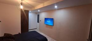 a bedroom with a blue screen on the wall at Chambre bain balneo indépendante in Valréas