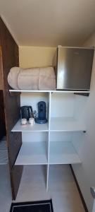 a small room with a bed and a shelf at Chambre bain balneo indépendante in Valréas