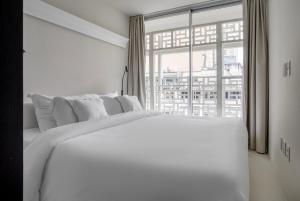 a white bedroom with a large white bed and a window at Tabas - Renata Edifício - Vila Buarque in São Paulo +33 photos
