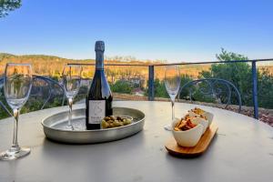 a table with a bottle of wine and wine glasses at Les Restanques in Paradou