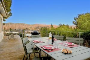 a table on a patio with a view of the mountains at Les Restanques in Paradou