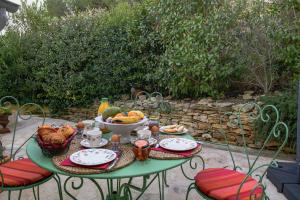 a green table with a bowl of fruit on it at Les Restanques in Paradou