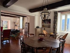 a dining room and living room with a table and chairs at La Bellevue in Valleraugue
