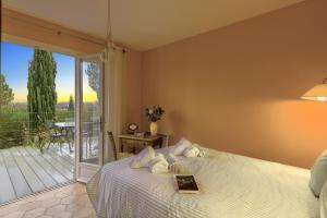 a bedroom with a bed with a book and a balcony at Les Restanques in Paradou