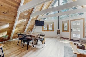 a living room with a wooden ceiling and a table and chairs at Elati Escape in South Lake Tahoe