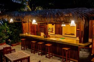 a bar with wooden stools in a restaurant at Jardin Vanille in Anjiabe +116 photos