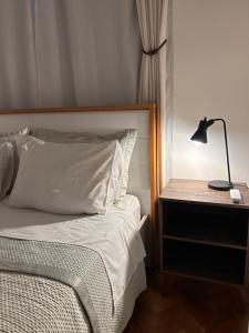 a bedroom with a bed and a lamp on a nightstand at Apê 5 min da praia de Copacabana, Pet Friendly in Rio de Janeiro