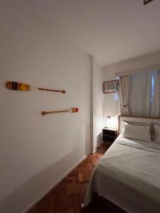 a bedroom with a bed and two baseball bats on the wall at Apê 5 min da praia de Copacabana, Pet Friendly in Rio de Janeiro