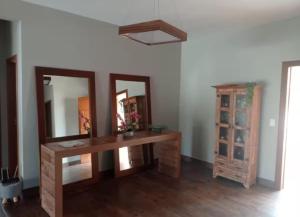 a room with a table and a mirror and a cabinet at Sitio Vila Monte Verde in Jaboticatubas