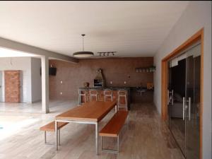 a living room with a wooden table and chairs at Sitio Vila Monte Verde in Jaboticatubas
