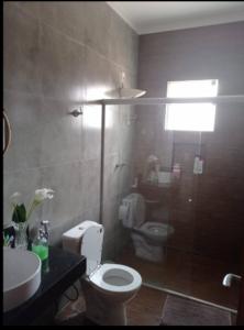 a bathroom with a white toilet and a sink at Sitio Vila Monte Verde in Jaboticatubas +5 photos