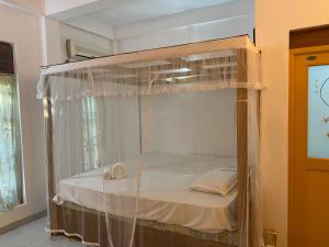 a canopy bed with two towels in a room at DEMITHA guest in Ranna