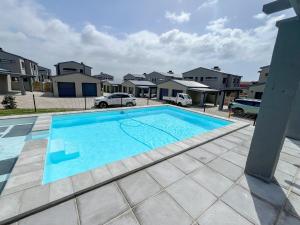 a large swimming pool in a yard with houses at 12 Langdown Ridge in Plettenberg Bay