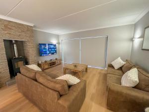 a living room with two couches and a tv at 12 Langdown Ridge in Plettenberg Bay