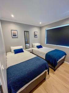 a hotel room with two beds and a large screen at 12 Langdown Ridge in Plettenberg Bay +4 photos