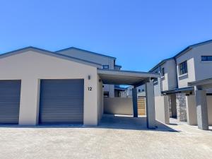 a parking lot with two garage doors on a house at 12 Langdown Ridge in Plettenberg Bay