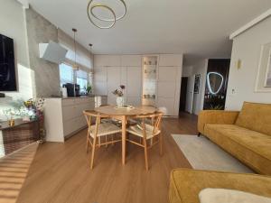 a kitchen and living room with a table and a couch at Apartamenty Zajazd u Marcela in Tuchola